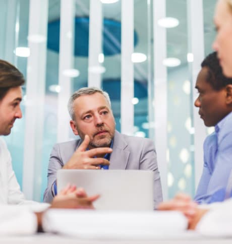 Project meeting around a laptop between engineers and partners